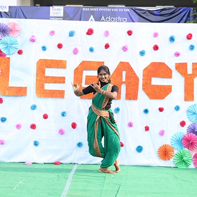 Performers showcase vibrant Indian dance traditions at Adastra '23 Legacy event, adorned in colorful attire.